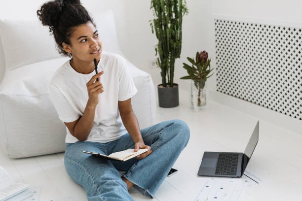 Young and thoughtful millennial girl doing homework