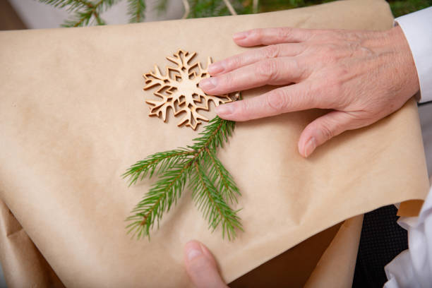 istock old women's hands, christmas gift packaging, fir branch, snowflake 1351642455
