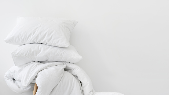 Duvet and pillows against white copy space background