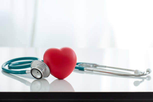 빨간 심장 사랑 모양 손 운동 공 과 의사 의정경 흰색 배경: 병원 생명 보험 개념: 세계 심장 건강 의 날. 의사의 날, 세계 고혈압의 날 - heart 뉴스 사진 이미지