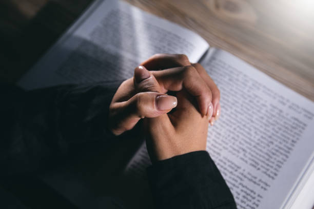 istock Woman hands praying with a Bible 1351644162