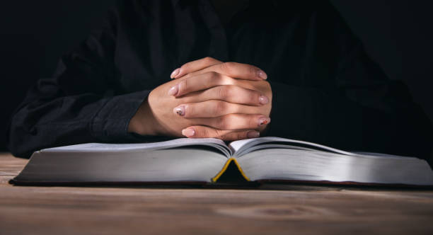 istock Woman hands praying with a Bible 1351644163