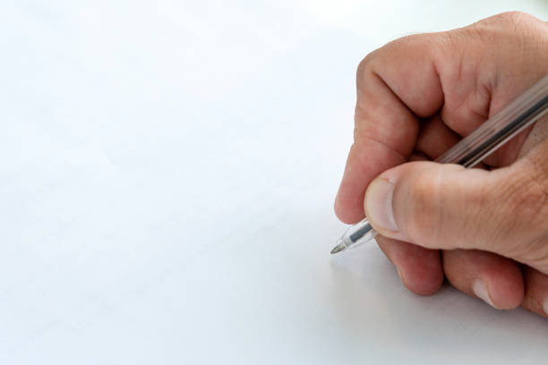 istock Human hand signing blank white sheet of paper using pen. copy space for text and design. a hand with a pen in close-up signs an empty paper document. 1351648016