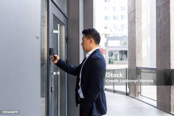 Successful Asian Businessman Opens The Door Of The Office Center Using A Smartphone And Nfc Application Stock Photo - Download Image Now