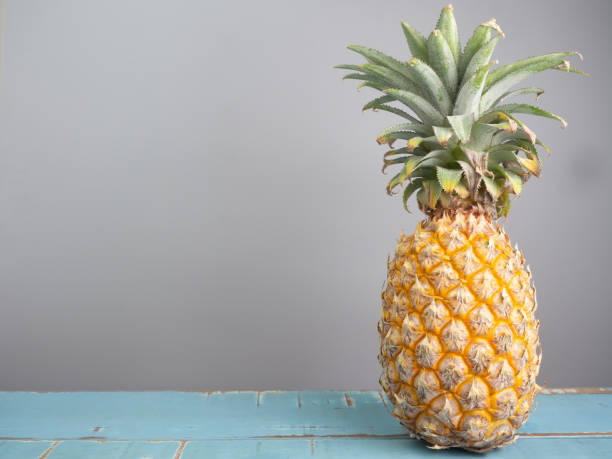 istock Ripe pineapple on a wooden table. 1351649547