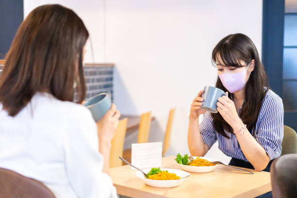 istock Two young women having lunch with mask on 1351651167