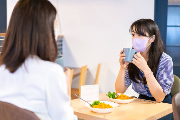 istock Two young women having lunch with mask on 1351651173