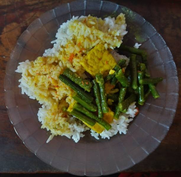almuerzo con arroz y guarniciones de verduras, frijoles largos, tempeh y curry. - beef rice orange stir fried fotografías e imágenes de stock