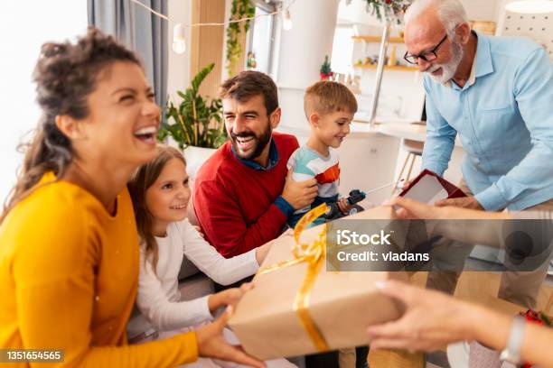 Family Exchanging Christmas Presents Stock Photo - Download Image Now - Gift, Christmas, Family