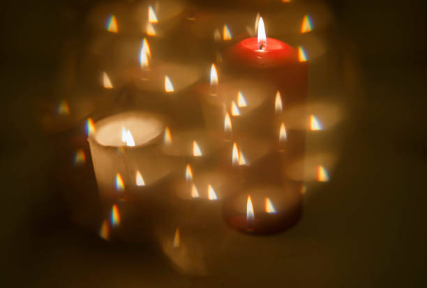 Red candle amongst small white candles reflecting in the mirror with a creative effect