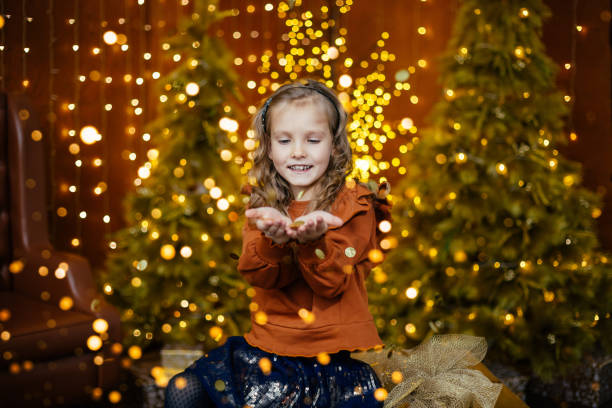 A beautiful girl makes a wish and looks at her hands in anticipation of a miracl.