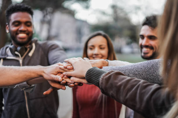 istock Multiracial young people celebrating together while stacking hands outdoor - Focus on hands 1351660098