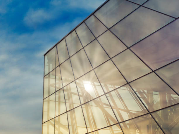 istock Modern glass building under the blue sky.Sun rays light effects on urban buildings. Abstract image of looking up at modern 1351665914
