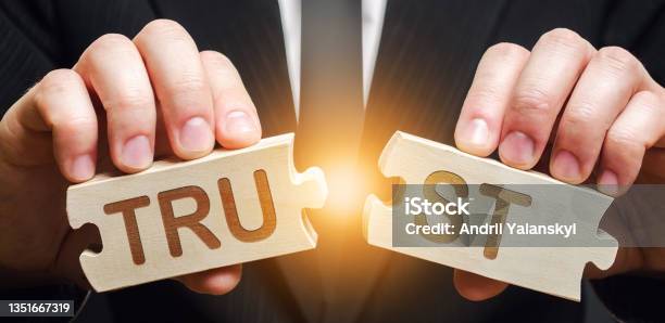 A Man Shares Two Puzzles With The Word Trust Violation Of Agreements And Promises Lose Credibility Failed To Maintain Professional Reputation Lie And Cheat Bad Consequences Not Trustworthy Stock Photo - Download Image Now
