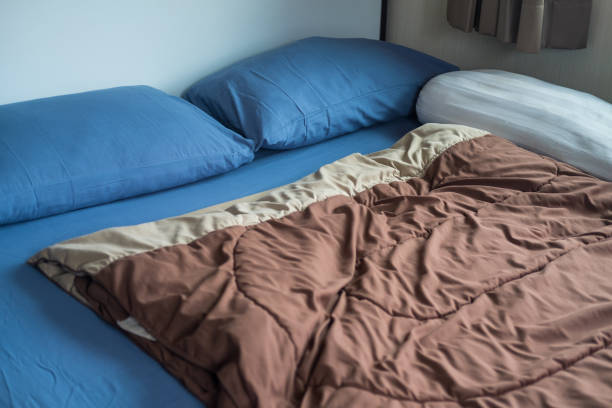 istock Blue pillows, brown duvet on a blue bed at home 1351667652