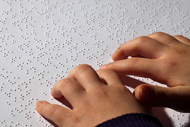 Young girl eading braille stock photo