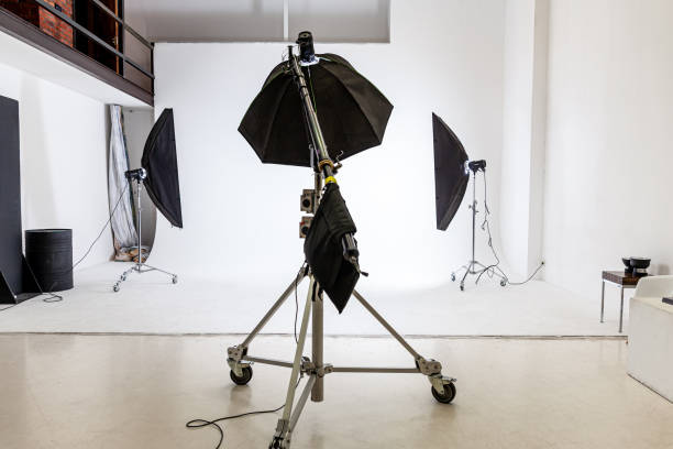 istock Empty photo studio with lighting equipment. Photographer workplace interior with professional tool set gear. Flash light white background scenes ready for studio shooting. Modern photographer studio 1351674650