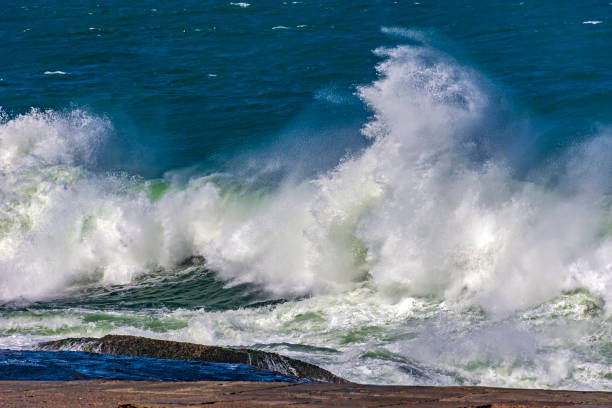 de fortes vagues s’écrasent contre des rochers - turbulence photos et images de collection