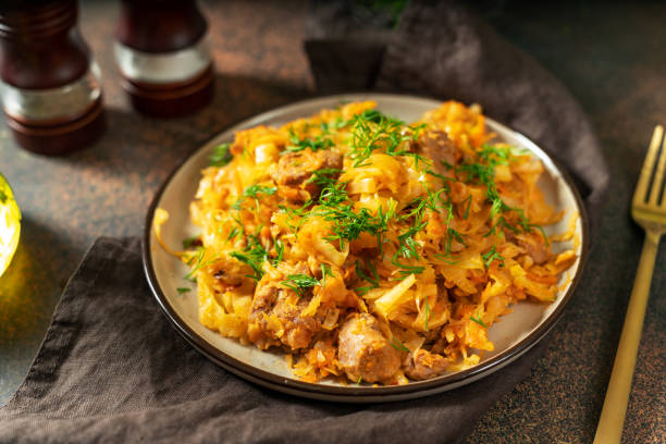 istock Braised cabbage. Stewed cabbage or bigos with turkey meat in a ceramic plate on a dark background. Traditional Polish dish 1351678246