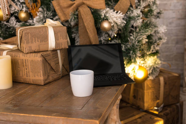 istock Christmas tree work on holidays. Cup and laptop next to the Christmas tree 1351678689