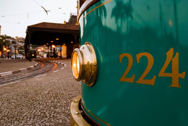 Close up of the front of old green tram showing the lit golden metal headlight. Santos city, Brazil. Santos, São Paulo - Brazil - April 4, 2009: Close up of the front of old green tram 224 showing the lit golden metal headlight. Blurred background showing the Valongo station and another tram arriving. 2009 stock pictures, royalty-free photos & images