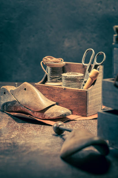 istock Vintage shoemaker workshop with with tools, anvil, shoes and rule. 1351684150