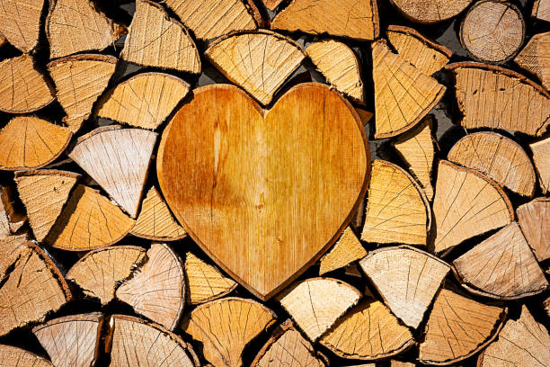 A stack of firewood with a wooden heart in the middle.