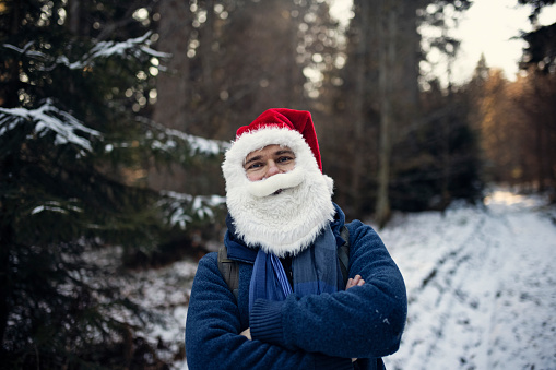 Santa Claus hiking in forest on winter day.\nShot with Canon R5