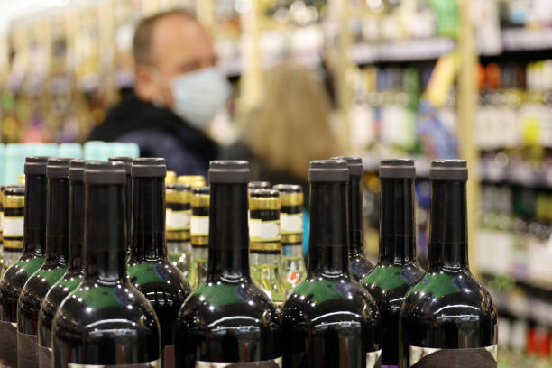 wine bottles in liquor store - eastern european caucasian one person alcoholism imagens e fotografias de stock