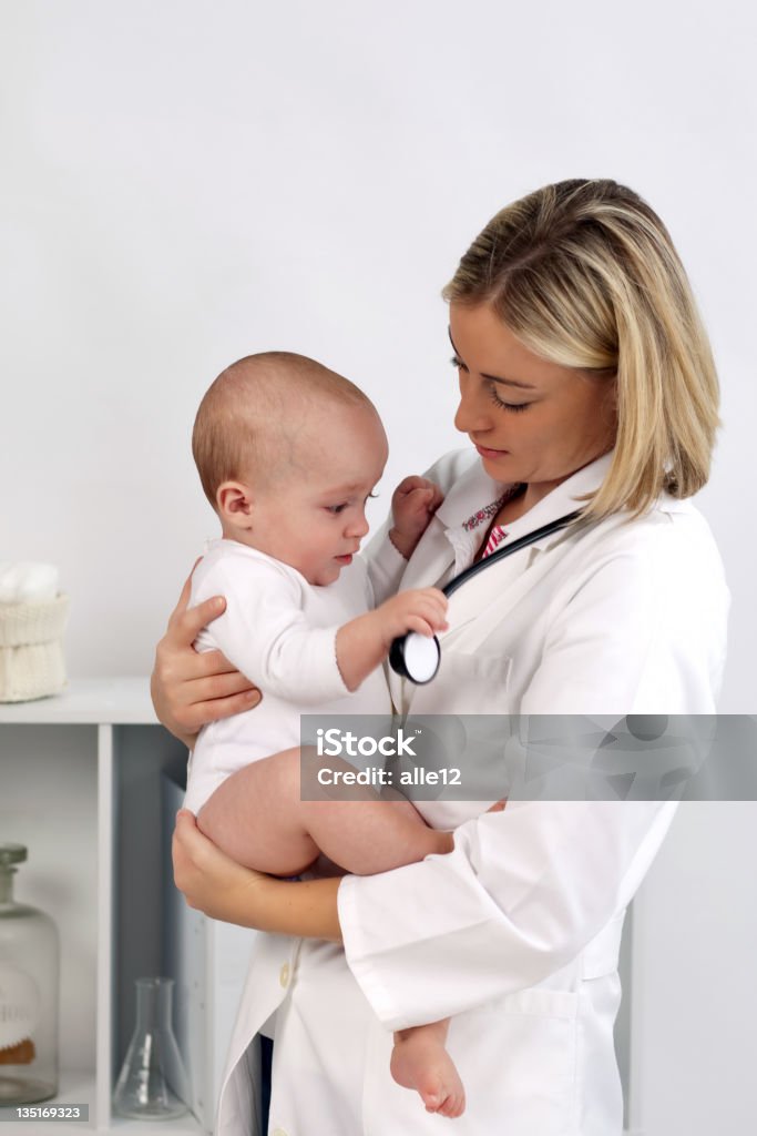 doctor joven un hermoso bebé - Foto de stock de Agarrar libre de derechos