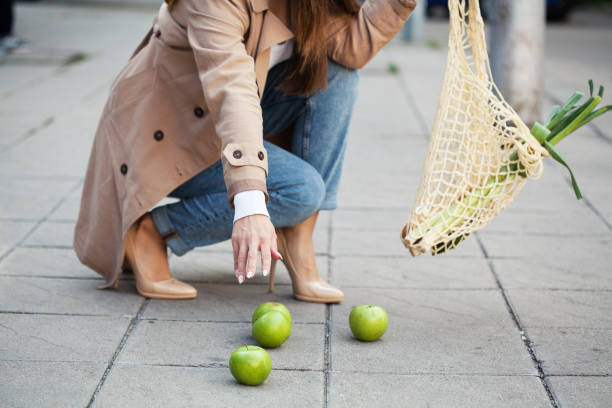 歩道に食料品を落とす若い女性 - granny smith apple apple food fruit ストックフォトと画像