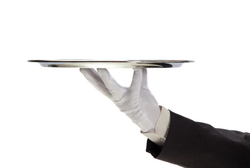 Butler holding empty silver tray in gloved hand.