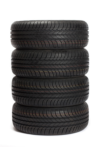 Brand new tires stacked up and isolated on white background. http://www.tomasworks.com/dusan/CARS&TIRES.jpg 