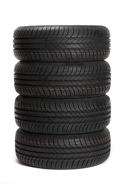 Photo of Four black car tires stacked on top of one another