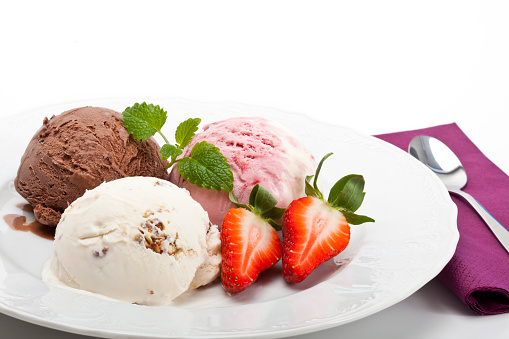 Set of bowls with various colorful Ice Cream scoops with different flavors and fresh ingredients, chocolate, vanilla, and strawberry with white plate