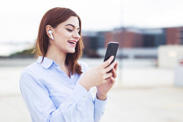 istock Young redhead manager with smartphone laughing outdoors 1351708941