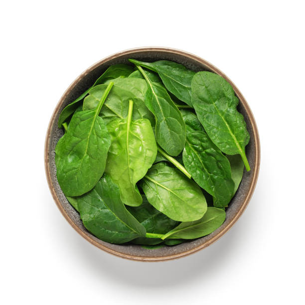 istock Fresh spinach with drops in a bowl isolated on white background. Top view. 1351710039