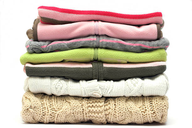 Pile of colored sweaters isolated on white  stock photo