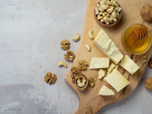 istock farm cheese served with honey and nuts on a light texture background. Copy space 1351718147