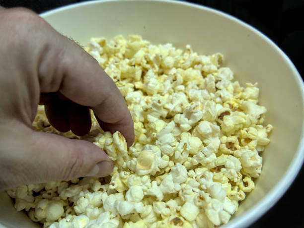 istock A man is taking popcorn from the bowl, close up 1351725652