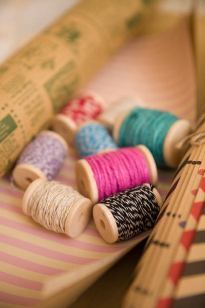 istock spools of colorful thread on holidays wrapping paper. Gift packing. Material for present package. Christmas, birthday and celebration concept 1351725962