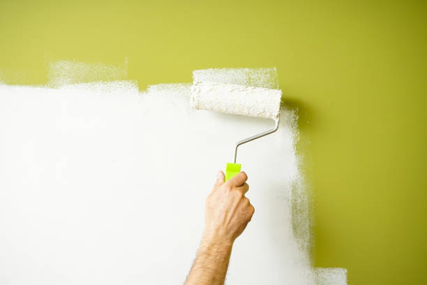 istock Male decorator painting wall with roller indoors. Painting work. 1351732219