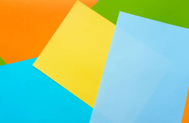 istock A five sheets of colored paper (blue, turquoise, yellow, green, orange) are mixed. Design cardboard background, copy space. 1351733112