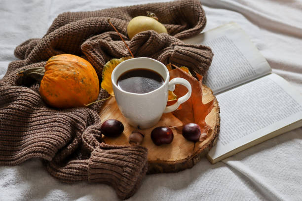 istock Cup of coffee in bed and autumn decorated background 1351741299