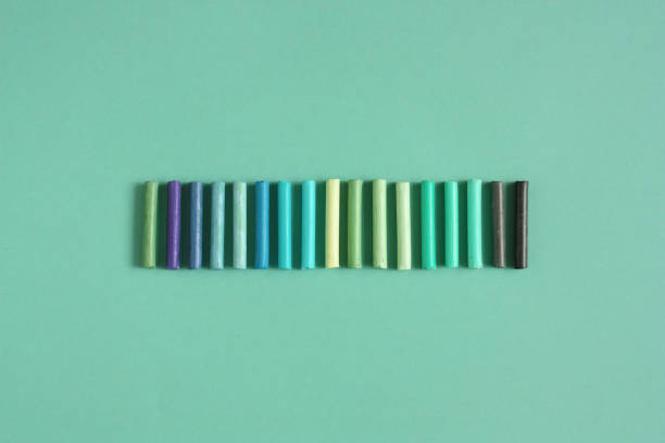 istock Colored pastels crayons on a green background. Green palette. Top view 1351748194
