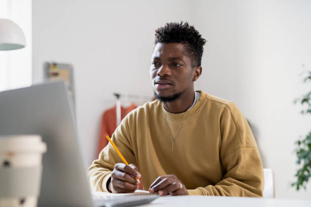 istock Tense young man with pencil looking at laptop screen 1351753214