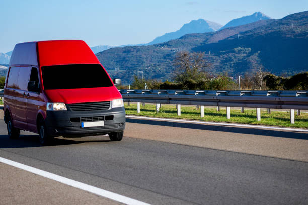 istock Red van on the highway and mountains besides. 1351754121