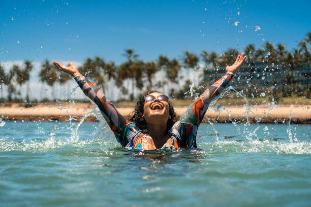 Woman bathing with splash on beach stock photo