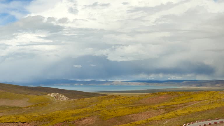 4k car driving on the meander road,distance lake namtso & mountain in tibet.