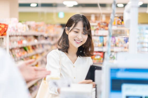 Young woman using self-checkout and e-money payment Young woman using self-checkout and e-money payment asian cashier stock pictures, royalty-free photos & images